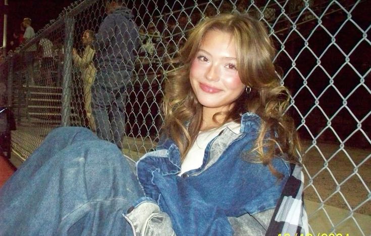 Night out digicam portrait by chain-link fence